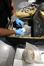 Funkcjonariusz celno-skarbowy odkrył podwójne dno w walizce.