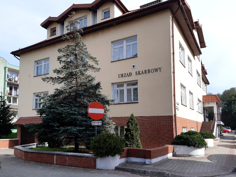 Budynek Urzędu Skarbowego w Mławie . Przed budynkiem drzewo.