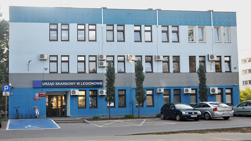 Budynek Urzędu Skarbowego w Legionowie. Przed budynkiem parking i trzy samochody.