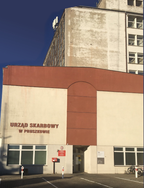 Budynek Urzędu Skarbowego w Pruszkowie. Przed budynkiem parking.