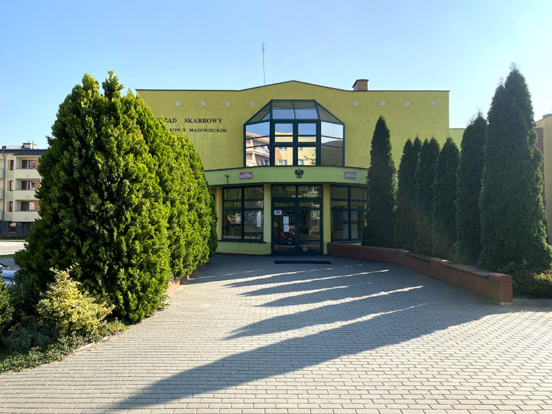 Budynek Urzędu Skarbowego w Makowie Mazowieckim. Przed budynkiem chodnik, po bokach drzewa.