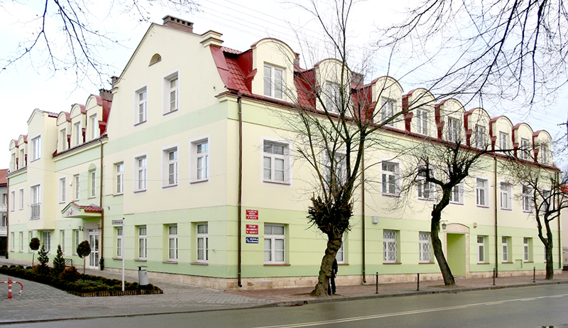 Budynek Urzędu Skarbowego w Sierpcu. Przed budynkiem drzewa i ulica.
