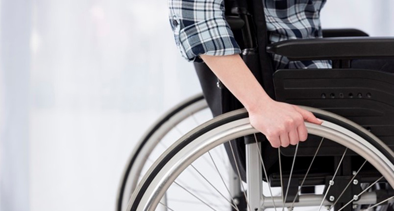 Ujęcie osoby siedzącej na wózku inwalidzkim.