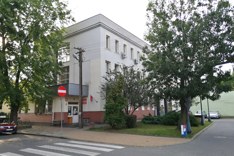 Budynek Urzędu Skarbowego w Sochaczewie. Przed budynkiem drzewa i ulica.