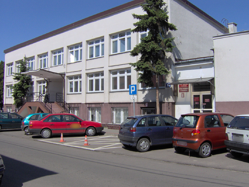 Budynek Urzędu Skarbowego w Garwolinie. Przed budynkiem parking i samochody.
