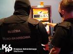 Funkcjonariusze Służby Celno-Skarbowej stoją przed automatem do gry