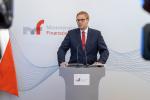 Minister Jan Sarnowski podczas konferencji na tle banera MF