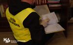 Funkcjonariusz przegląda dokumenty w trakcie działań kontrolnych