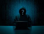 Sylwetka hakera piszącego na laptopie