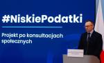 Minister Soboń podczas konferencji oraz napis niskie podatki, projekt po konsultacjach społecznych.
