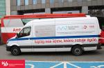 Samochód do transportu krwi z napisem: Łączy nas krew, która ratuje życie na tle ambulansu.