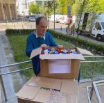 Mężczyzna stoi przy pudełkach z nakrętkami.