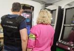 Dwoje funkcjonariuszy Służby Celno-Skarbowej stoi przed automatami do gry