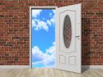 Otwarte drzwi, za którymi widać piękne błękitne niebo.