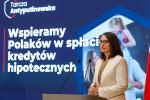 Magdalena Rzeczkowska - minister finansów - na tle prezentacji Wspieramy Polaków w spłacie kredytów hipotecznych