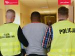 Funkcjonariusze Służby Celno-Skarbowej oraz policji prowadzą zatrzymanego.