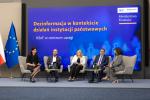 Panel dyskusyjny z pięcioma osobami siedzącymi na scenie podczas konferencji o dezinformacji w kontekście działań instytucji państwowych, organizowanej przez Ministerstwo Finansów i Human Answer Institute.