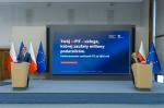 Grafika dekoracyjna, kobieta i mężczyzna przy mównicach, w tle ekran multimedialny z wyświetloną prezentacją dot. danych z akcji PIT za 2025r.