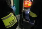 Dwie osoby w ciemnych ubraniach z odblaskowymi opaskami „Służba Celno-Skarbowa
