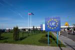 Przejście graniczne z Unią Europejską. Baner Unii Europejskiej, w oddali flaga Unii Europejskej i flaga Polski, przejście dla samochodów osobowych.