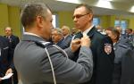 Komendant Wojewódzki Policji dekoruje funkcjonariusza celnego brązowym medalem Za zasługi dla policji.