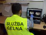 Funkcjonariusz celny wskazuje kapsułki z narkotykami na obrazie tomografu