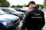 Funkcjonariusz celno-skarbowy obok samochodów na parkingu
