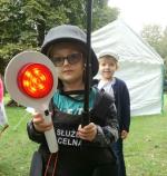 Dziecko z lizakiem do kierowania ruchem w kamizelce kuloodpornej i hełmie