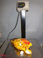 Na zdjęciu waga i żółta torba z cukierkami. Wynik ważenia to ponad kilogram nielegalnej substancji.