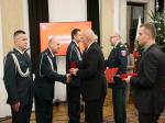 Funkcjonariusze odbierają medale z rąk ministra finansów Tadeusza Kościńskiego