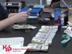 Na zdjęciu widać funkcjonariusza KAS, który przelicza pieniądze ujawnione w kontrolowanym lokalu