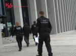 Troje funkcjonariuszy Służby Celno - Skarbowej prowadzi jednego z podejrzanych do budynku sądu